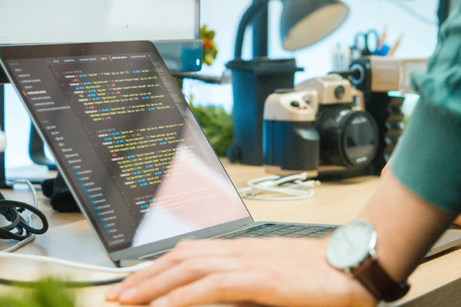 A photo of a person looking at code on a laptop computer.